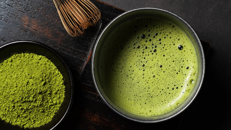 bamboo whisk, matcha powder, and frothed matcha water