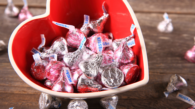 Hershey's Kisses wrapped in pink and silver wrappers, in a chocolate heart