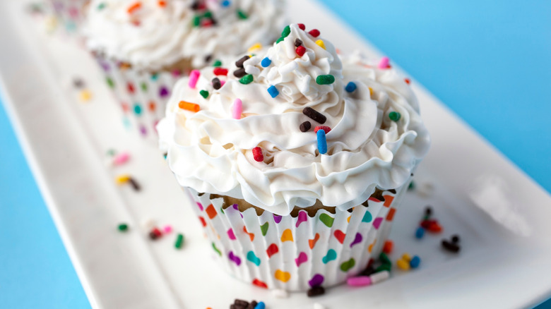 A cupcake decorated with Funfetti frosting and sprinkles.