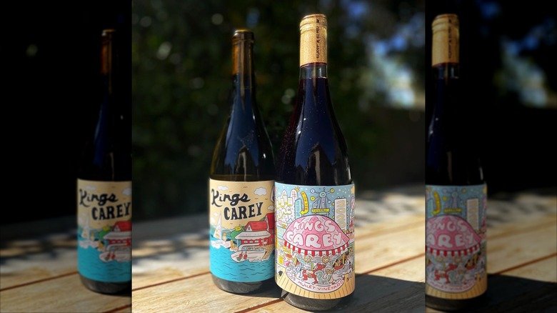 Two colorful wine bottles from Kings Carey on wooden table