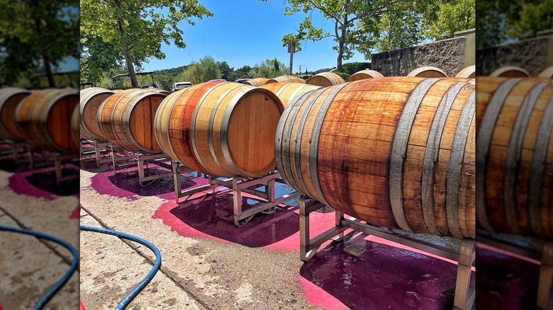 Wine barrels in the sun, the ground below stained with wine