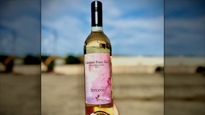 A hand holding a bottle of Tercero Cabernet Franc Rose