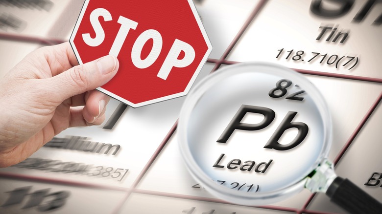 Periodic table with magnifying glass over lead and a stop sign
