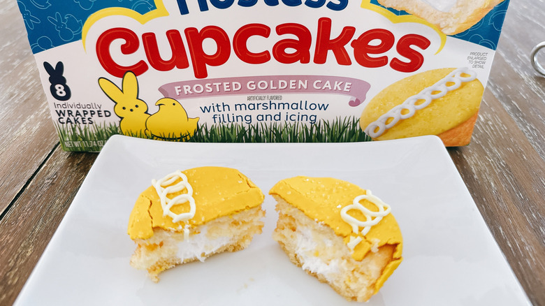 Cut open Hostess Peeps Cupcake on white plate with box in background