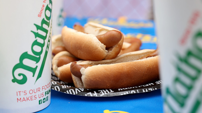 Plate of Nathan's Famous hot dogs between two soda cups