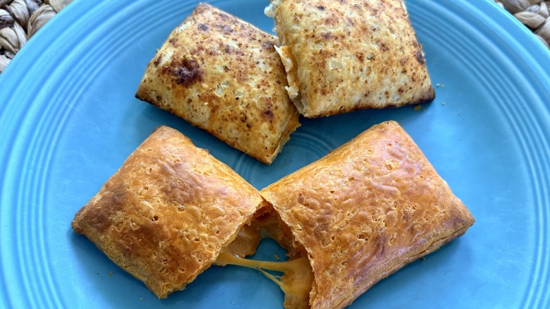 Two microwaved Hot Pockets Snack Breaks split on a blue plate