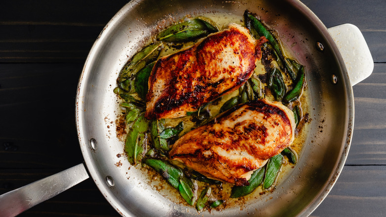 skin-on chicken in frying pan