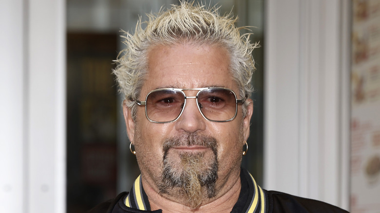 a close-up of Guy Fieri wearing sun glasses outside