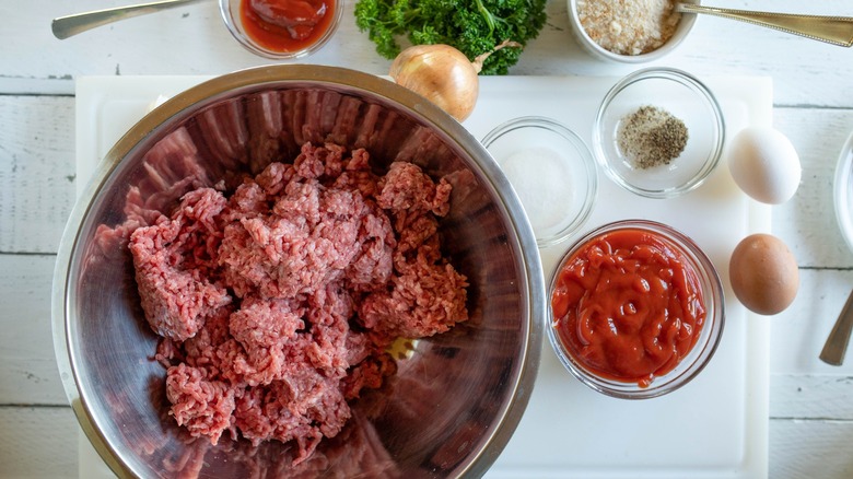 Ingredients for making meatloaf including ground meat and seasonings