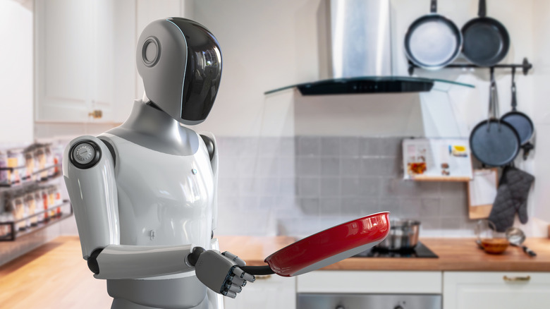 A robot in kitchen with red frying pan