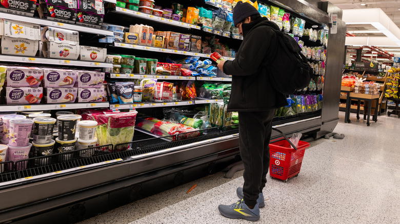 A shopper reads the label on a food item in a Whole Foods stocked dairy section