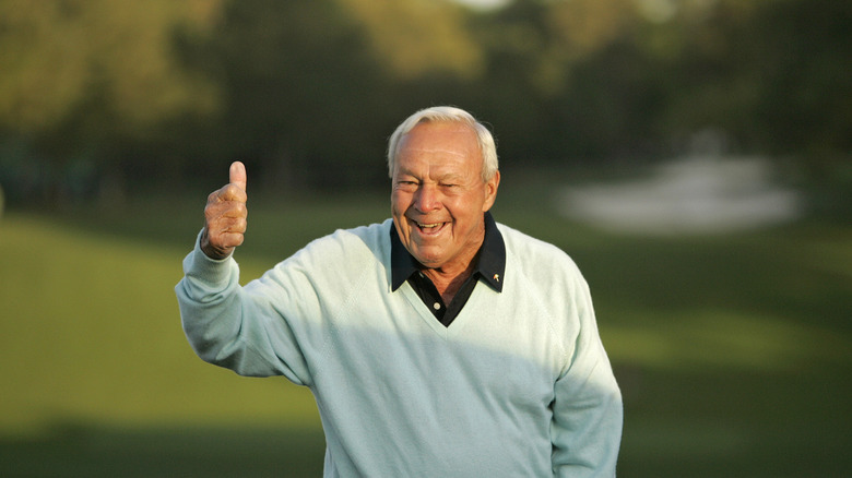 Arnold Palmer giving a thumbs up on a golf course