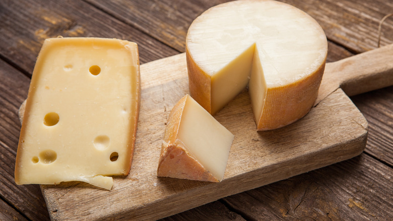 A variety of hard cheeses on a wooden board