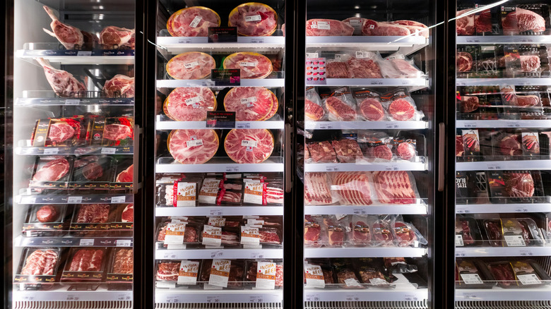 Various frozen meats stored in a store fridge