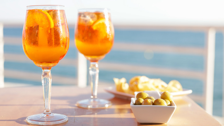 Aperol spritz cocktails with olive and potato chips