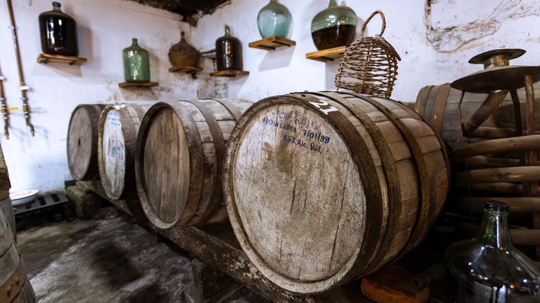 Old oak tequila barrels and bottles of tequila