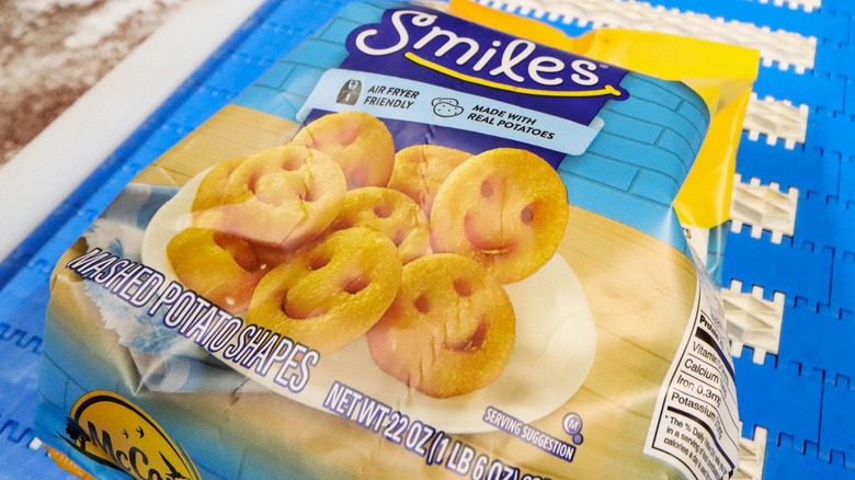 A bag of Smiles smiley fries rest on a conveyor belt