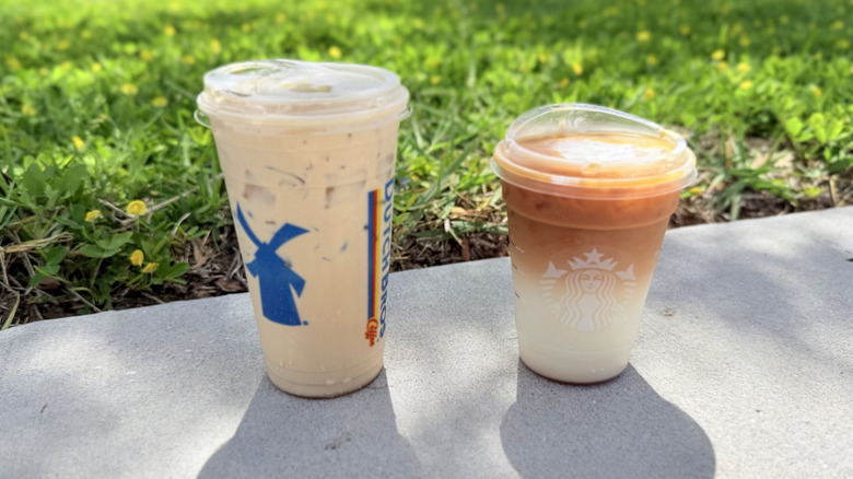 Iced lattes from both Dutch Bros and Starbucks side by side outdoors