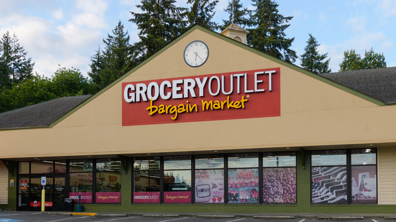 Grocery Outlet bargain market sign on the tan store facade along with a round clock