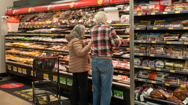 Elderly man and woman shopping for meat at a Grocery Outlet store