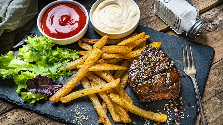 Steak with fries, ketchup, and mayonnaise