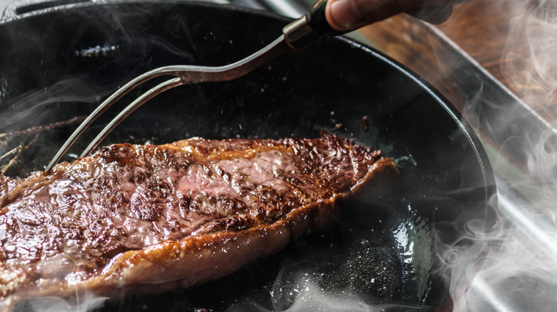 Steak being cooked in a pan