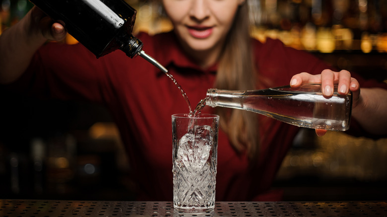 Pouring bottles into drink glass