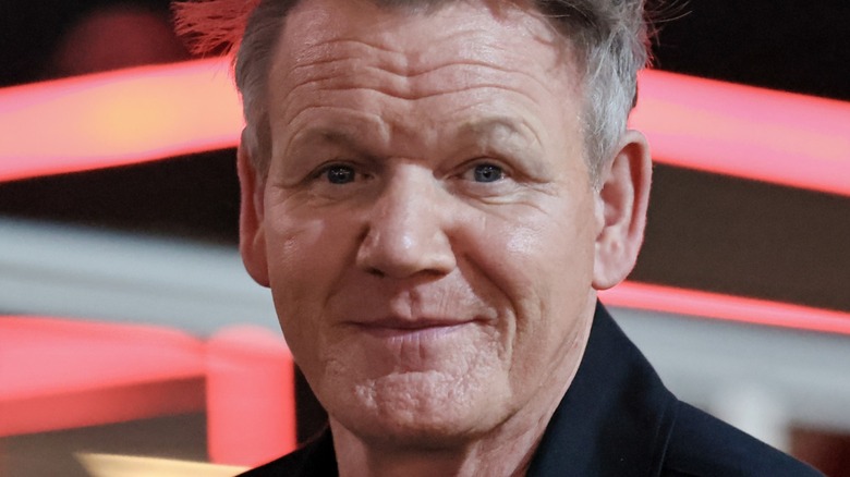 Closeup of Gordon Ramsay's face in front of pink, black, and white background