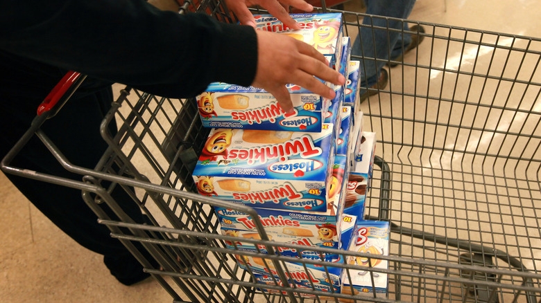 Twinkies being loaded into a shopping cart
