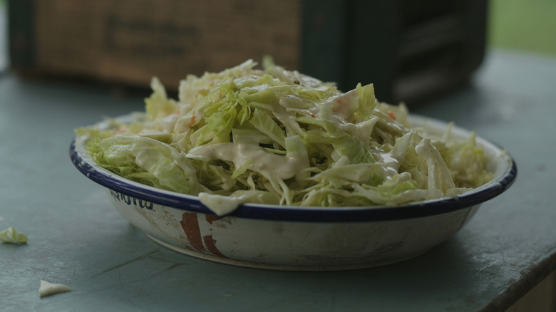 A bowl of coleslaw with creamy dressing on it.