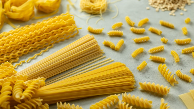 Different cuts of pasta laying down on gray surface