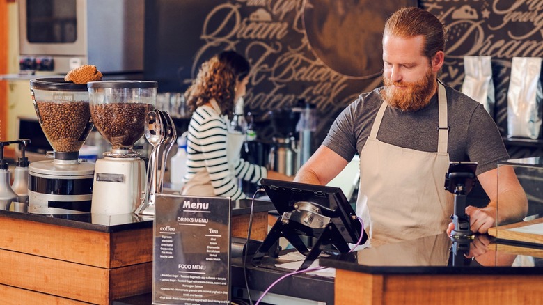 Person working on POS system in cafe