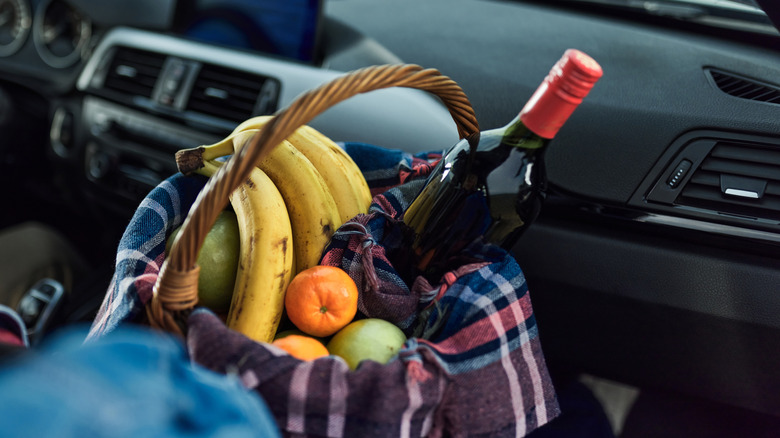 A basket of wine and fruit in a car