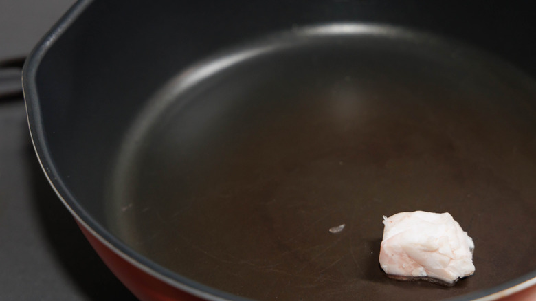 A black frying pan with white fat melting in it