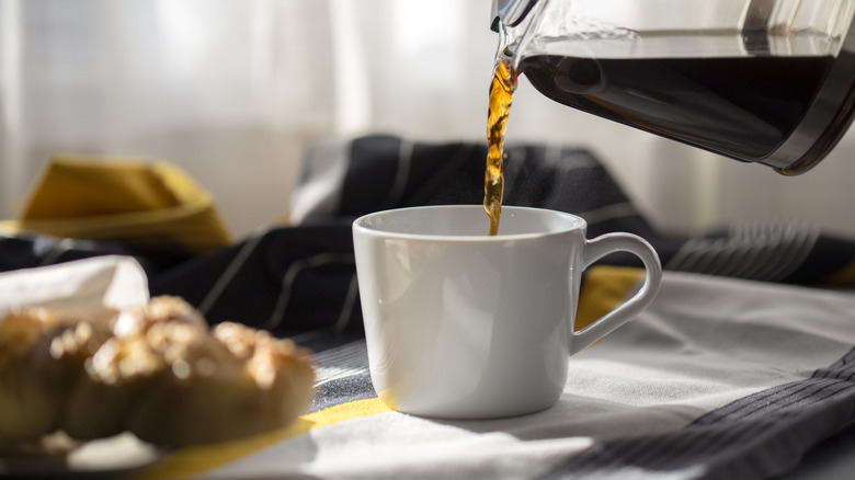 Coffee being poured into white mug