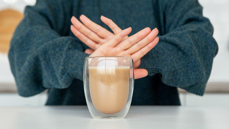 Woman saying no to coffee with creamer