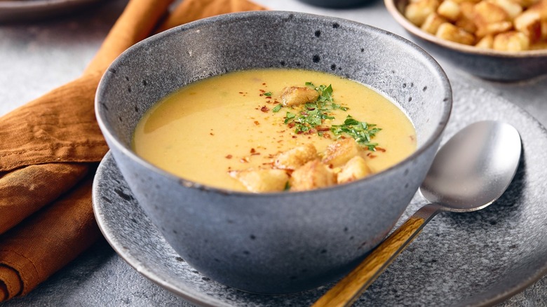 A bowl of mashed potato soup with a spoon