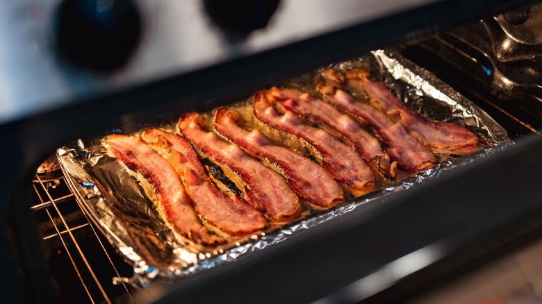 Bacon on foil-lined sheet pan in oven.