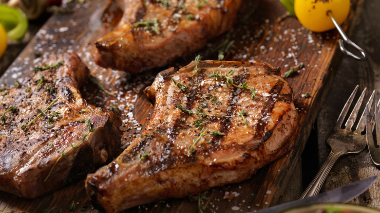 grilled pork chops on a wooden board
