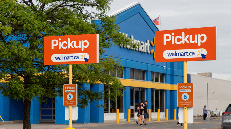 Signs for two Walmart pickup spaces against a Walmart location exterior