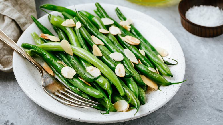 Green beans with sliced almonds on plate with fork