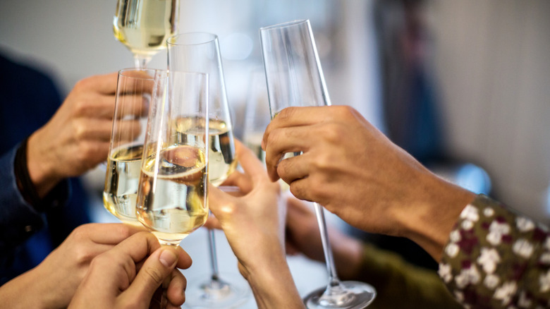 Hands clinking champagne flutes in a toast