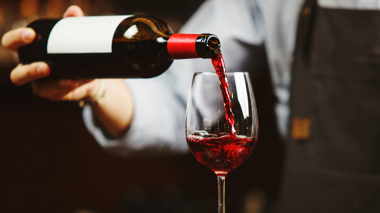 Server pouring red wine
