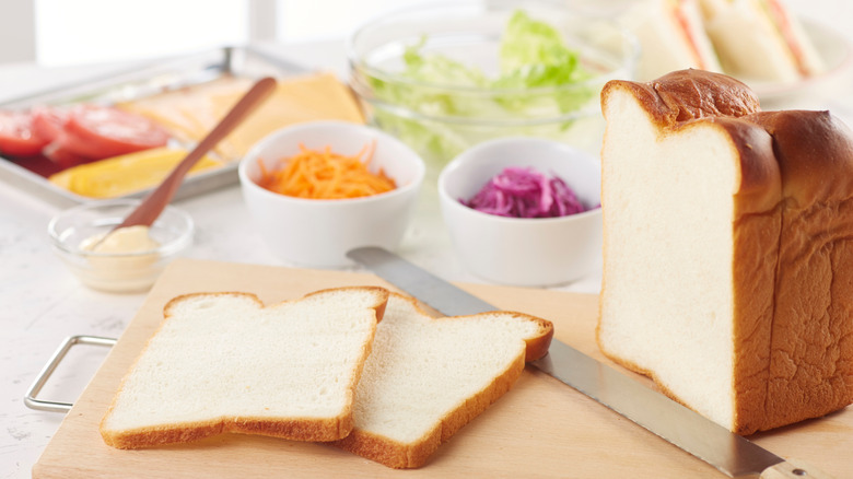 Sandwich preparation ingredients including bread, cheese, and lettuce