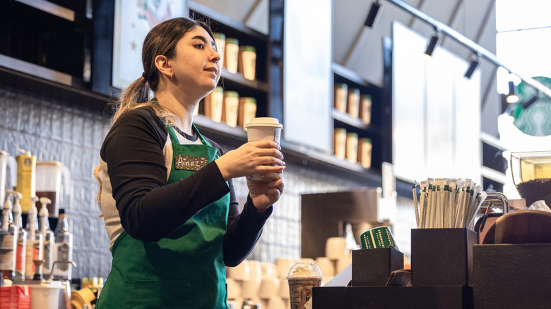 A Starbucks barista calls out an order for a drink