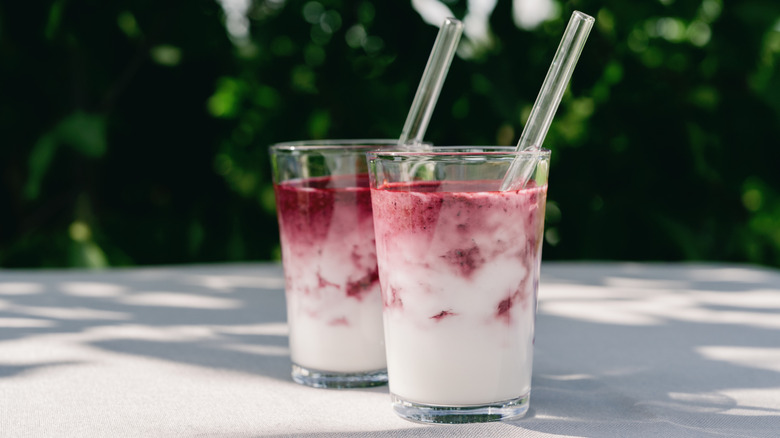 Two smoothies with glass straws.