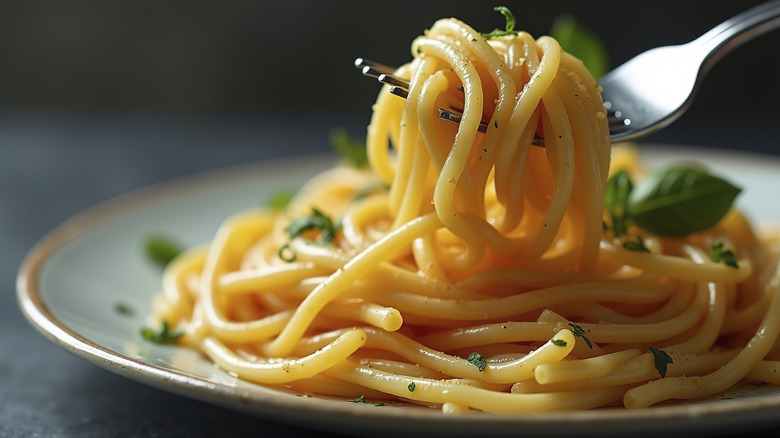 A bowl of a spaghetti, with a fork lifting one portion of the pasta