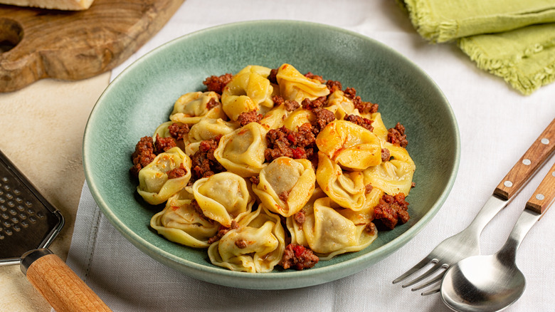 tortellini with bolognese sauce in a blue bowl