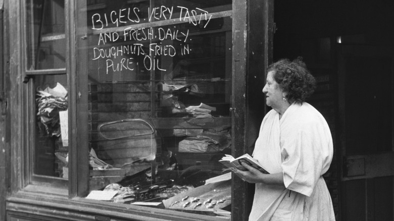 A woman outside a turn-of-the-century Jewish grocery store.