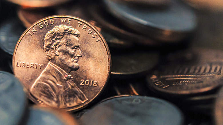 A penny, head side showing, against a background of coins